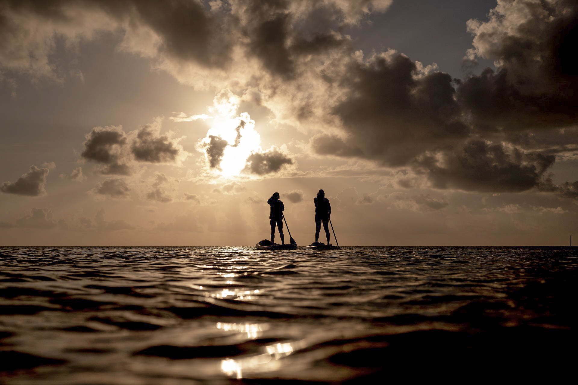 Stand-up paddleboarding at sunset on the ocean